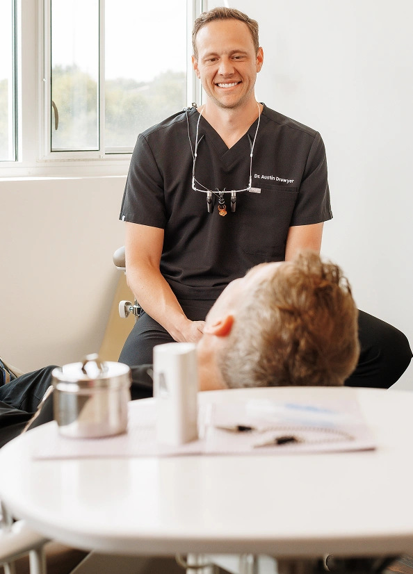 Smiling dentist Dr. Austin Dwayner greets a patient during a dental consultation in Burtonsville.
